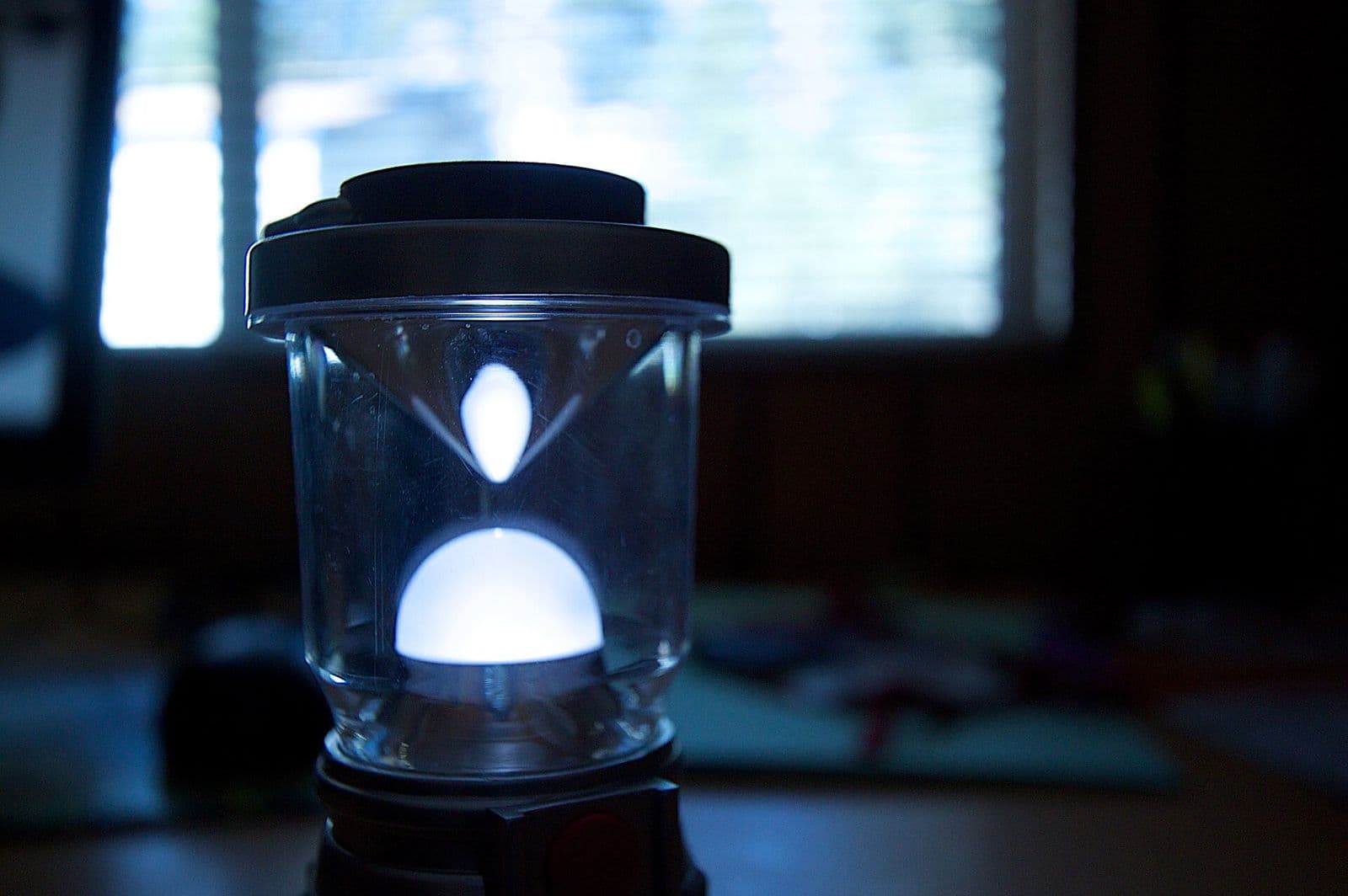 Glow Rechargeable Camp Lantern, alternate view: Close-up of a lit lantern with a frosted diffuser glowing in a dark room