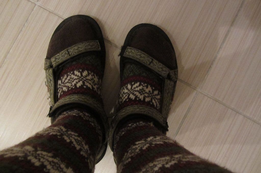 Thumbnail: Feet in patterned wool socks and sport sandals on a tiled floor