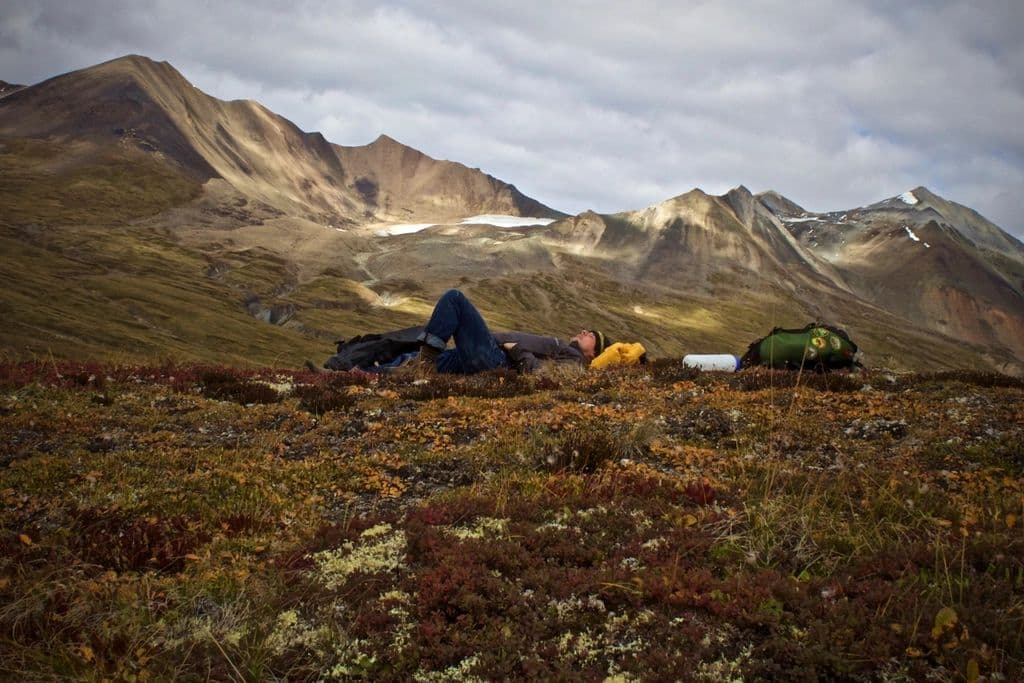 Thumbnail: Small tents pitched on autumn tundra beneath rolling mountains